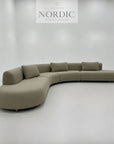 Moderne sofa med buet form, rummelig siddeplads og valgfrit premium stof til stuen