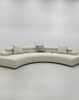 Skulpturel designsofa med rene linjer i creme stof til moderne hjem