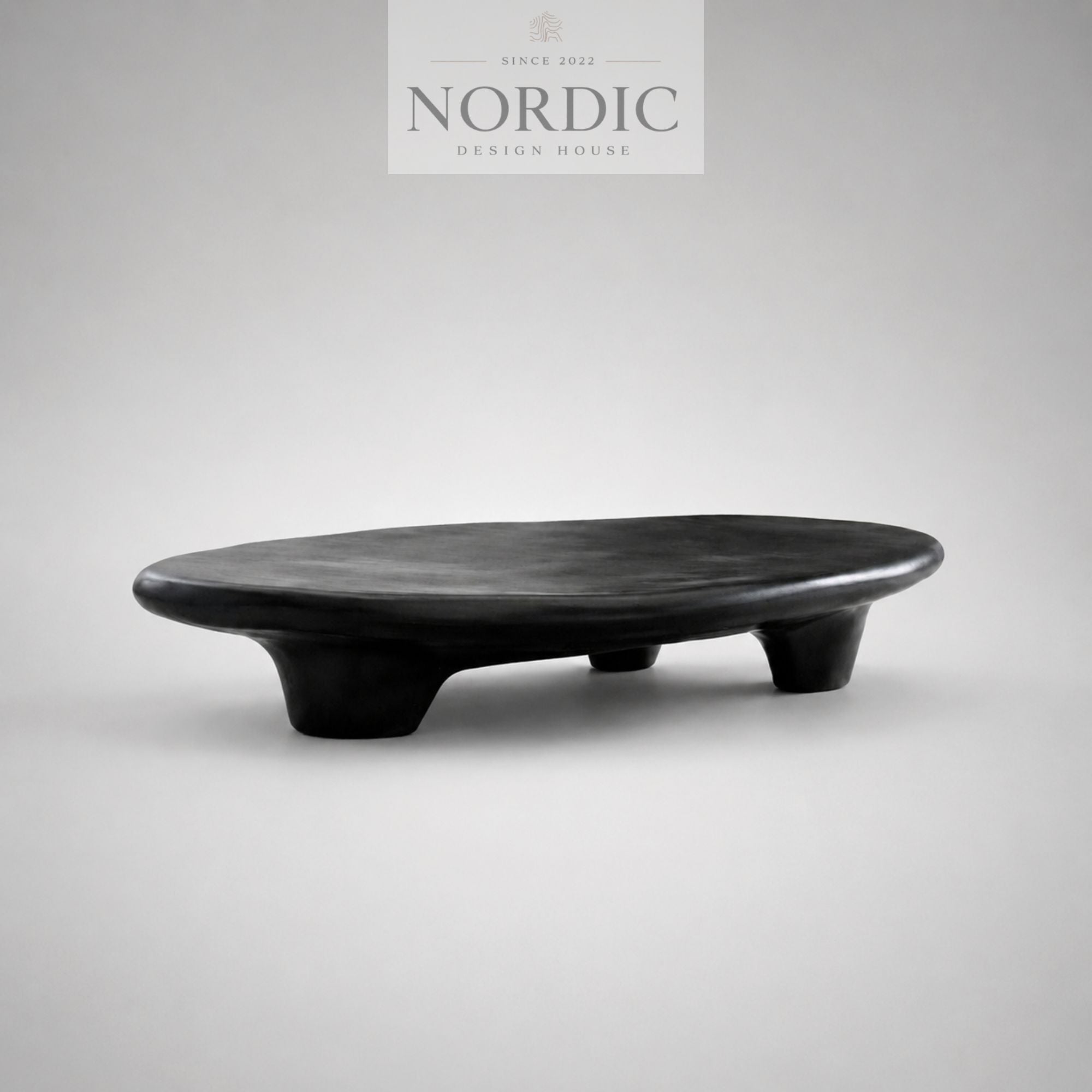 Lavt sort sofabord i skulpturelt design med blød organisk form
