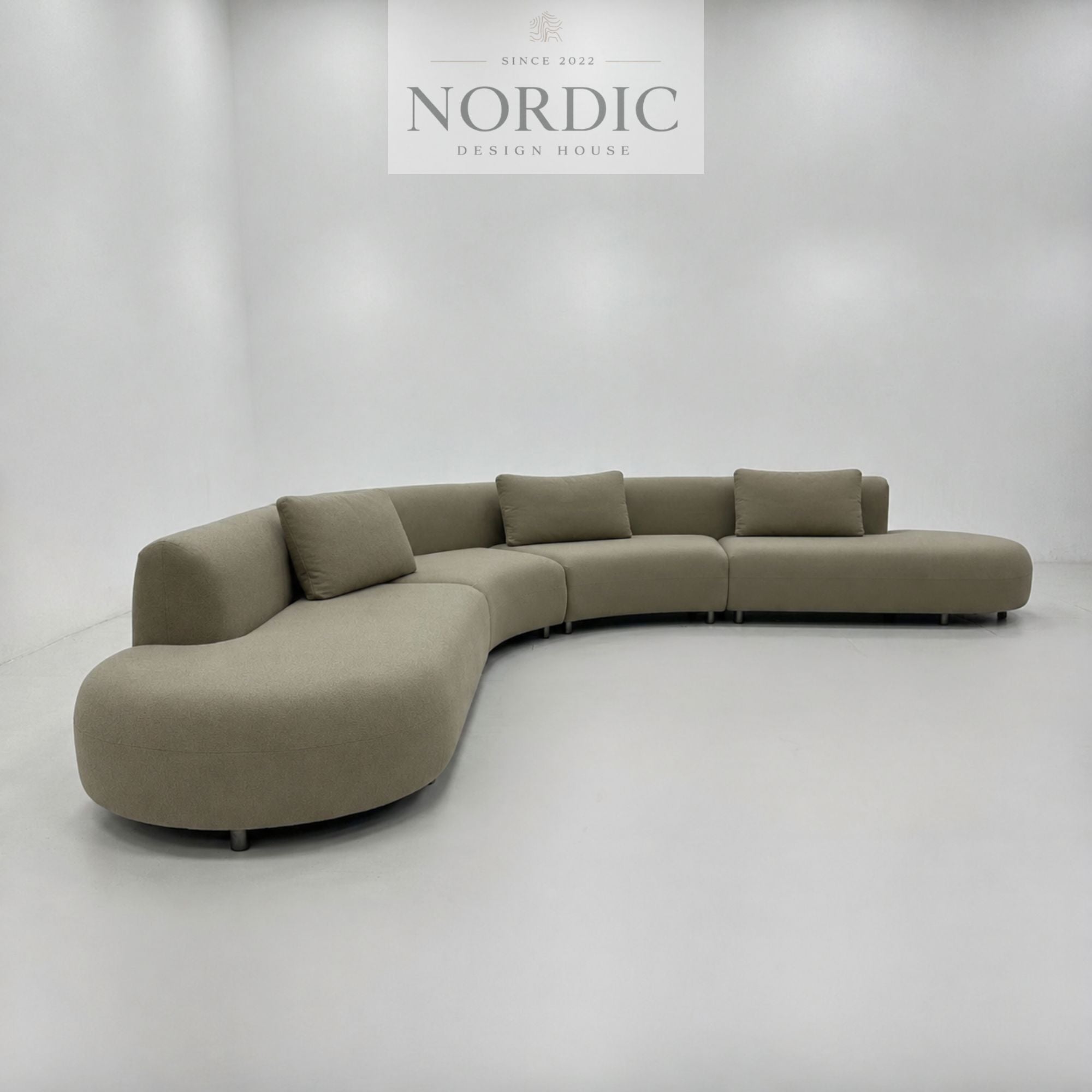 Moderne sofa med buet form, rummelig siddeplads og valgfrit premium stof til stuen
