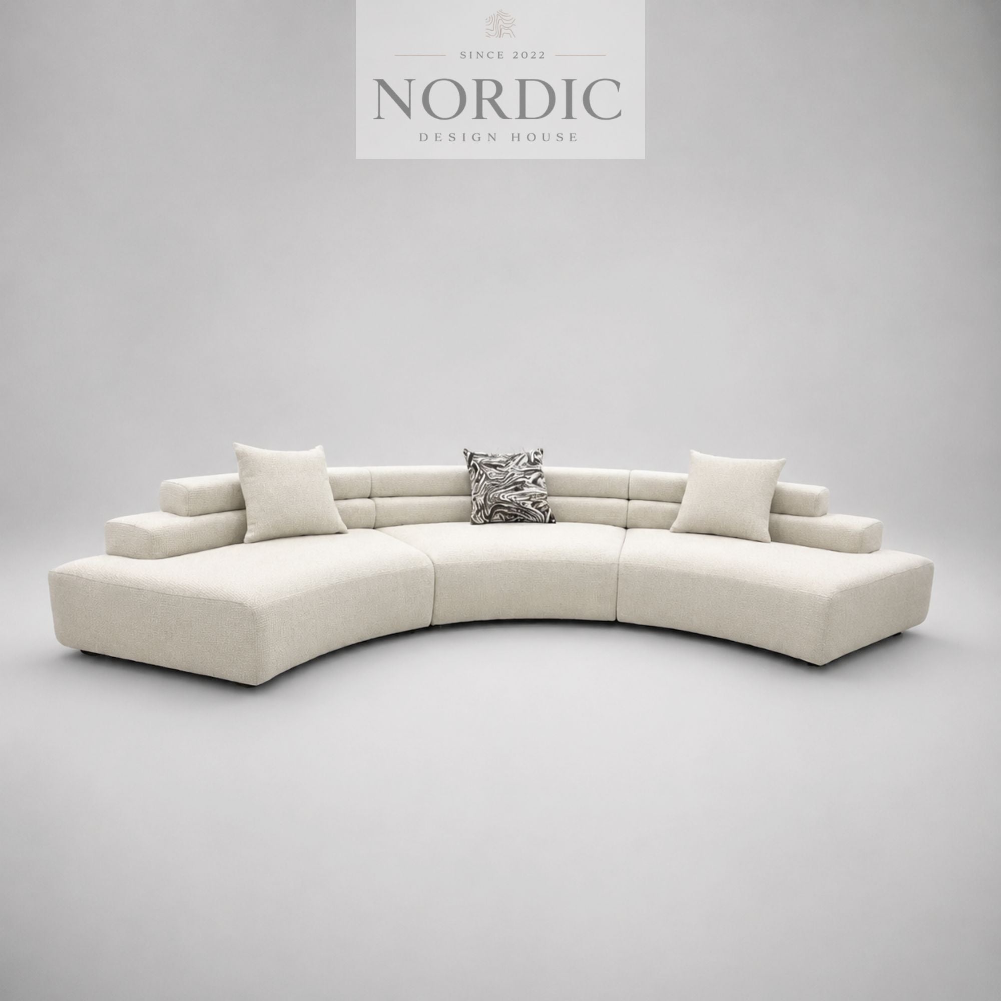 Skulpturel designsofa med rene linjer i creme stof til moderne hjem