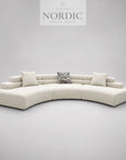 Skulpturel designsofa med rene linjer i creme stof til moderne hjem